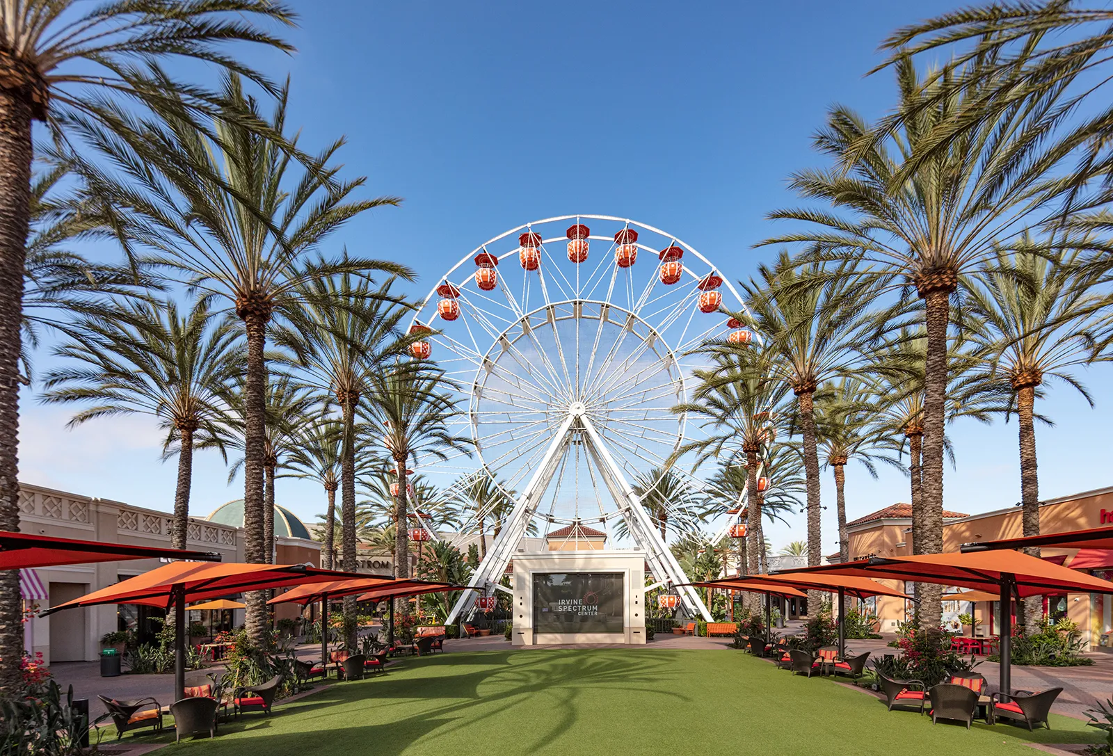The original Giant Wheel framed by palm trees above the central lawn at Irvine Spectrum Center in Irvine, California